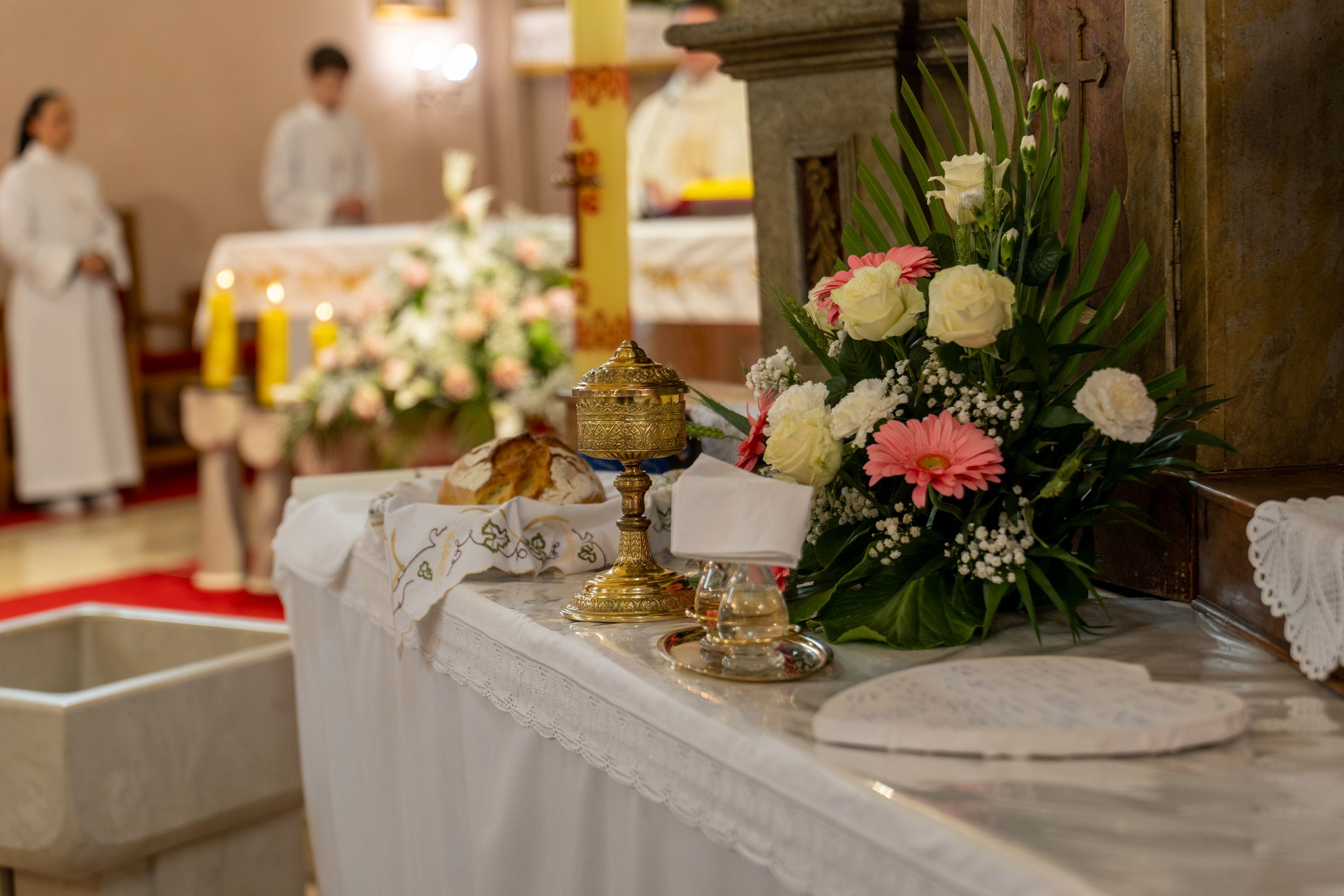 A decorative altar setup with flowers and eucharistic items in a church setting.