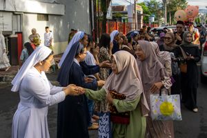 Interfaith gathering with nuns and Muslim women greeting each other in Indonesia.
